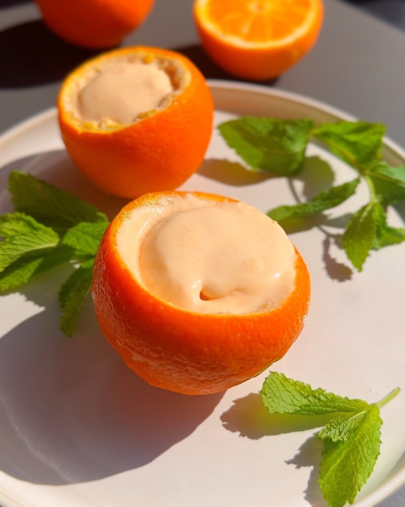 Summer-desserts-Aperol-Spritz-ice-cream.jpg - Ems Foodie Fix Aperol spritz ice cream in orange cups on a plate with mint leaves.