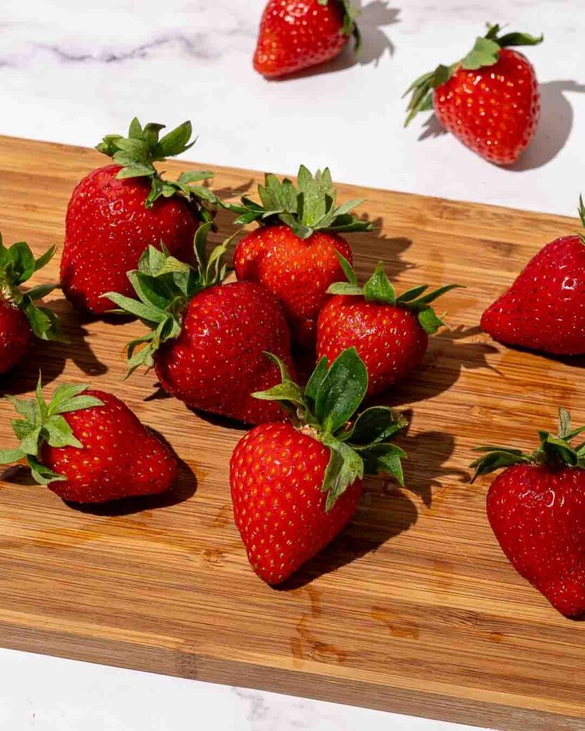 Strawberries on a wooden chopping boards.