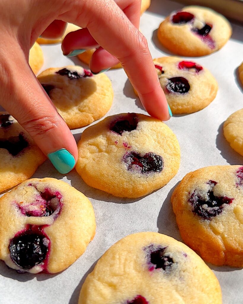 Mini blueberry cookies on a baking tray.