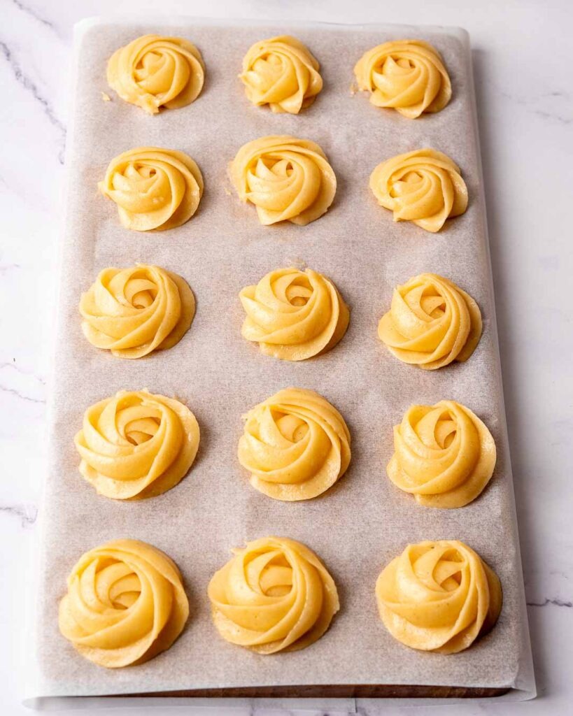 Mini churro swirls piped into a baking sheet before going in the oven