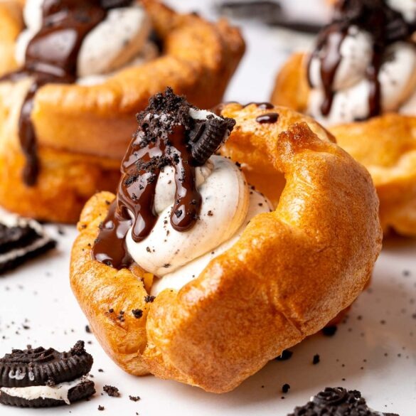 Yorkshire pudding with a Oreo cheesecake filling topped with a piece of Oreo cookie and melted chocolate drip.