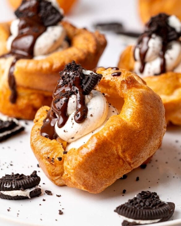 Yorkshire pudding with a Oreo cheesecake filling topped with a piece of Oreo cookie and melted chocolate drip.
