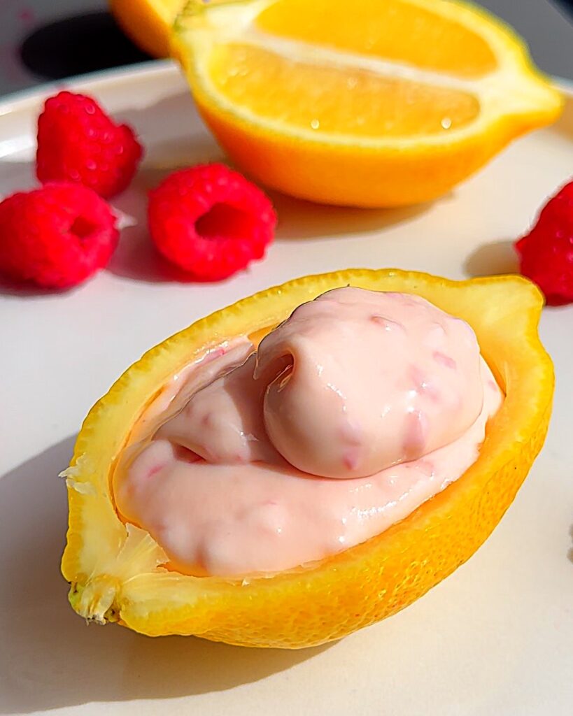 Limoncello and raspberry ice cream in a lemon cup before being frozen.