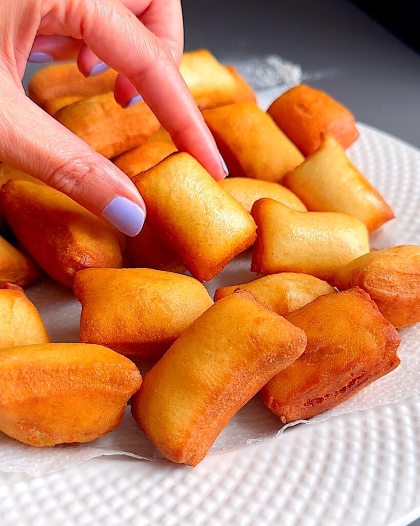 Mini beignets that have been fried on a plate.
