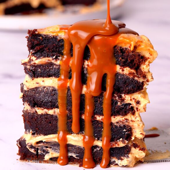 slice of chocolate fudge cake with caramel sauce drizzled down the side.