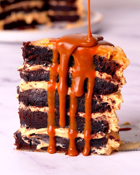 slice of chocolate fudge cake with caramel sauce drizzled down the side.