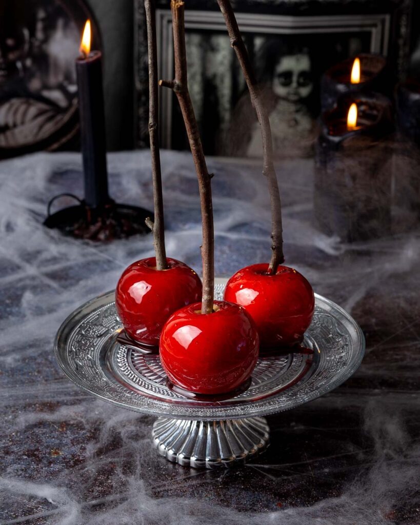 Three R
red candy apples on a silver cake stand.