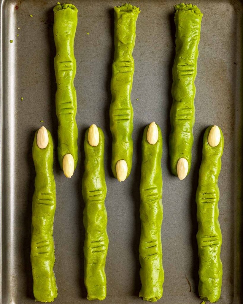 Witche finger cookies on a baking sheet before being baked.