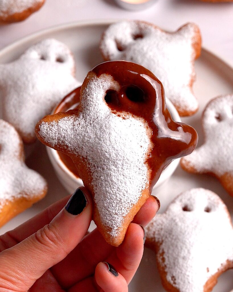 Ghost shape beigners for halloween covered in icing sugar and dipped in melted chocolate.