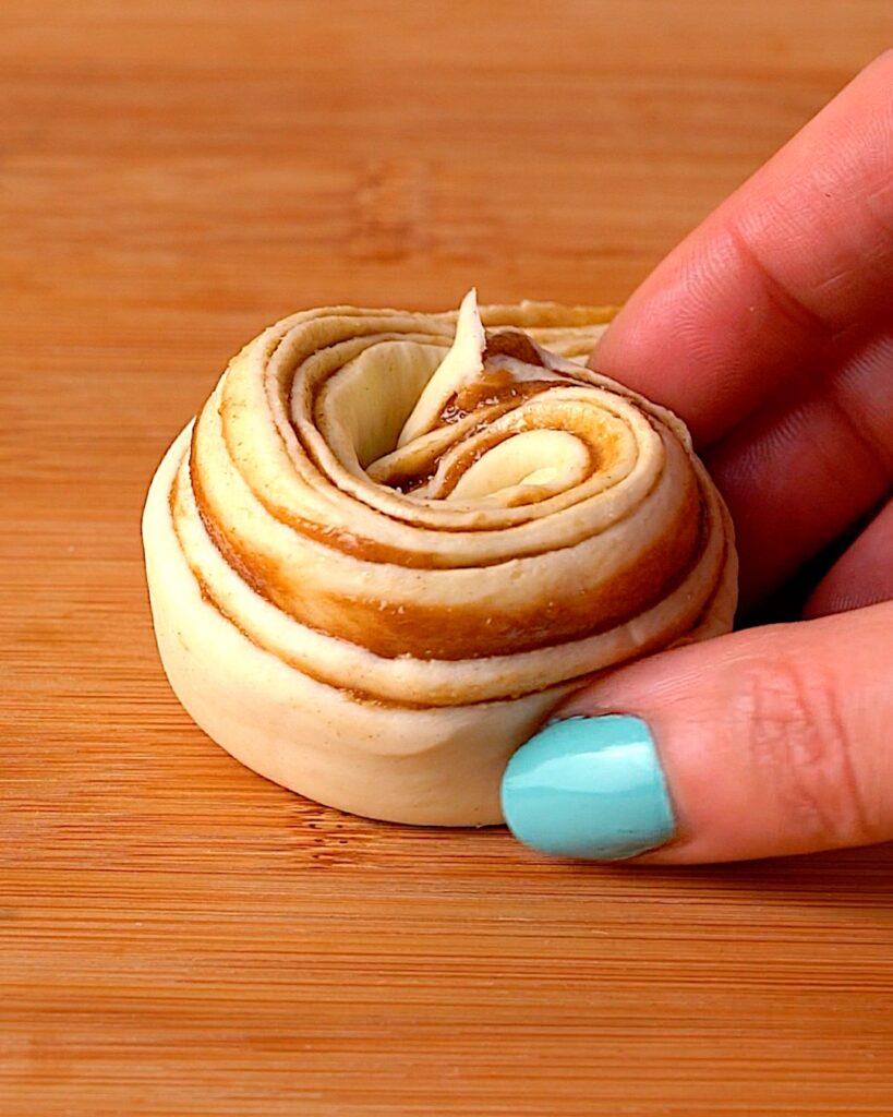 Cruffin being rolled into a rose shape.