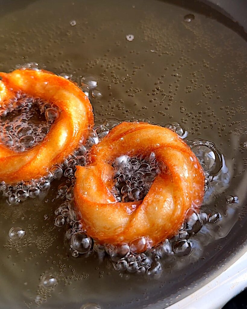 Churros being fried in oil.