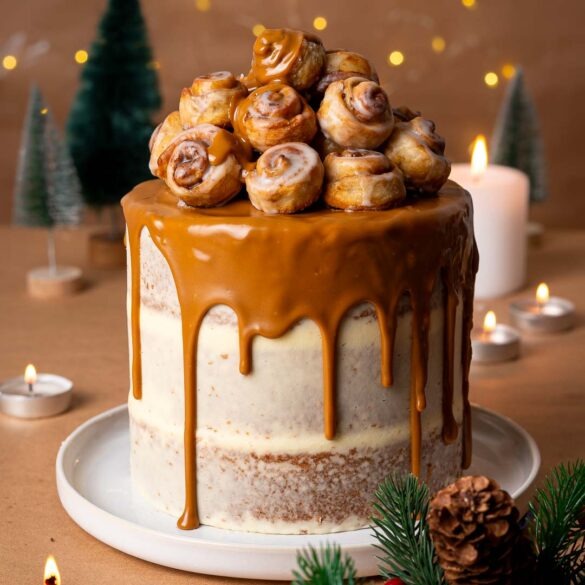 Biscoff drip cake with mini cinnamon rolls on top.