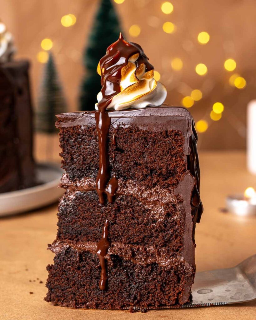 A slice of Chocolate fudge cake with melted chocolate drizzling down.