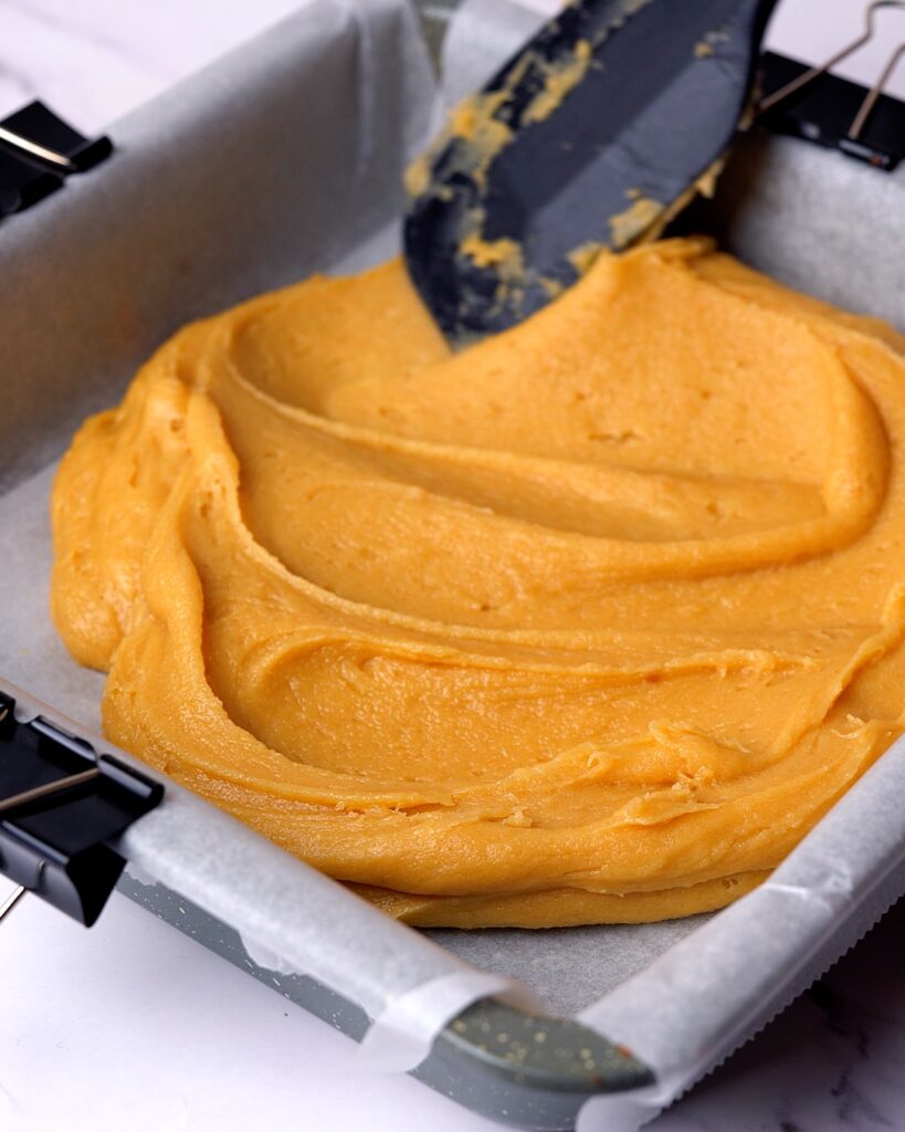 Blondie batter being spread into brownie tin.