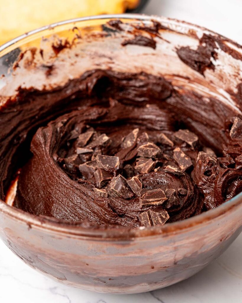 Brownie batter with chocolate chunks in a mixing bowl.