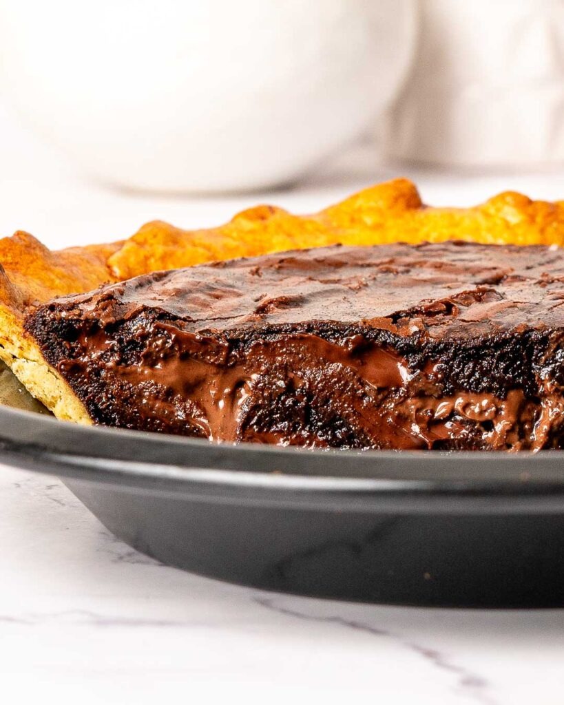 Nutella brownie pie cut in half in a pie tin.