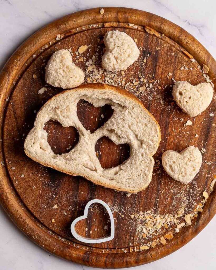 Heart shapes cut out of a slice of bread.