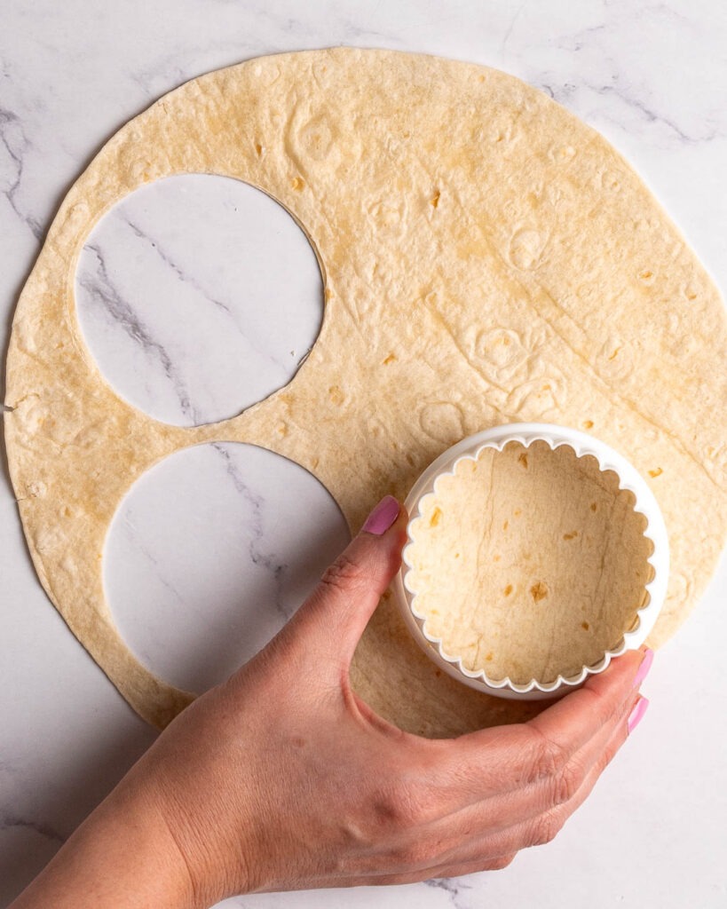 Cutting tortilla wrap with cookie cutter.