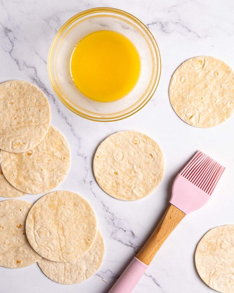 Mini tortillas before having melted butter spread on them.