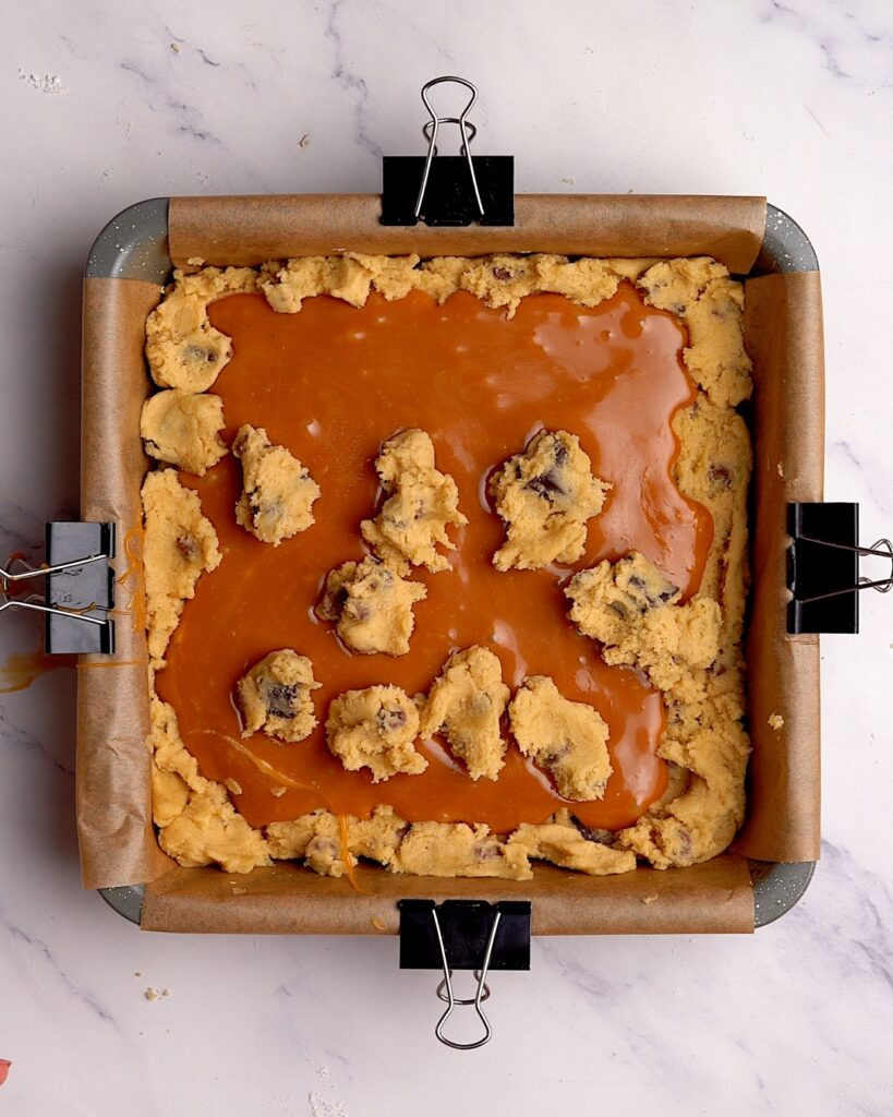 Carmel chocolate. chip cookie dough bars in a brownie tin before being baked.