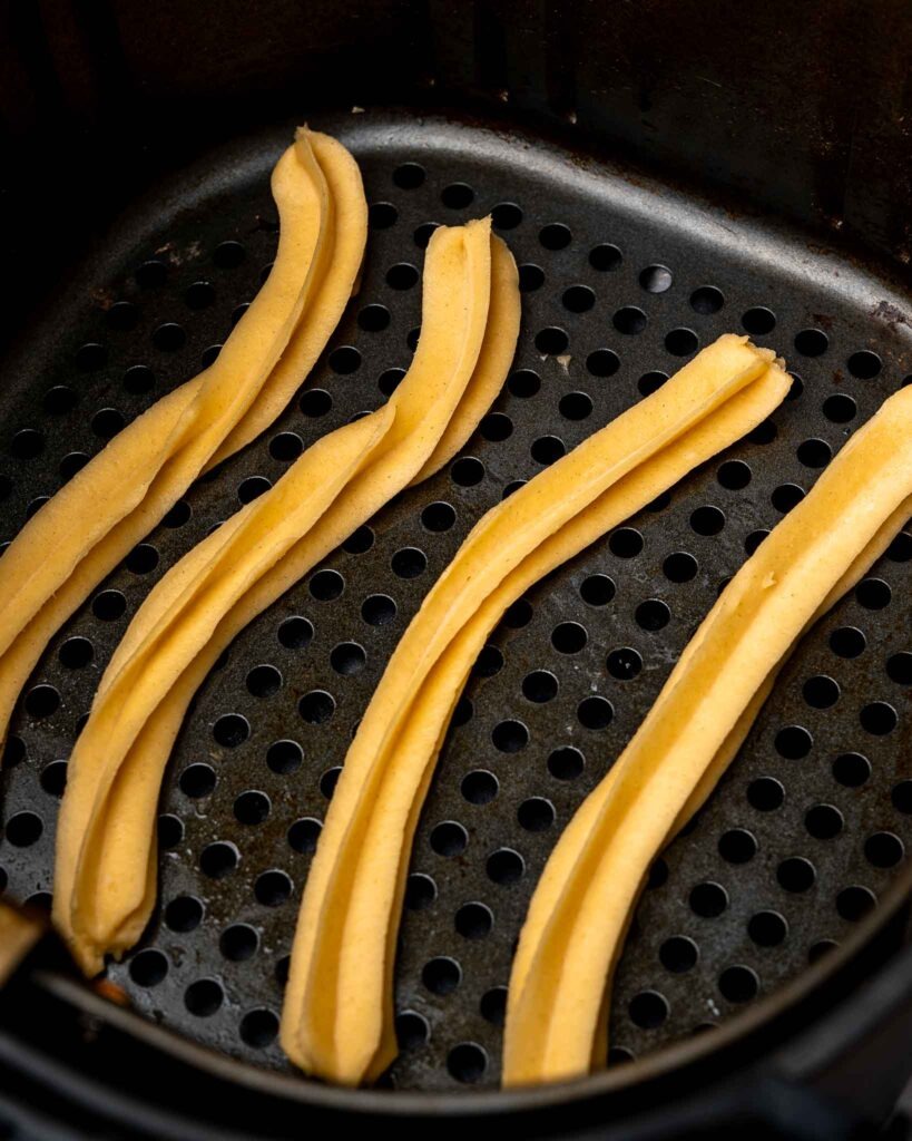 Churros in an air fryer basket.