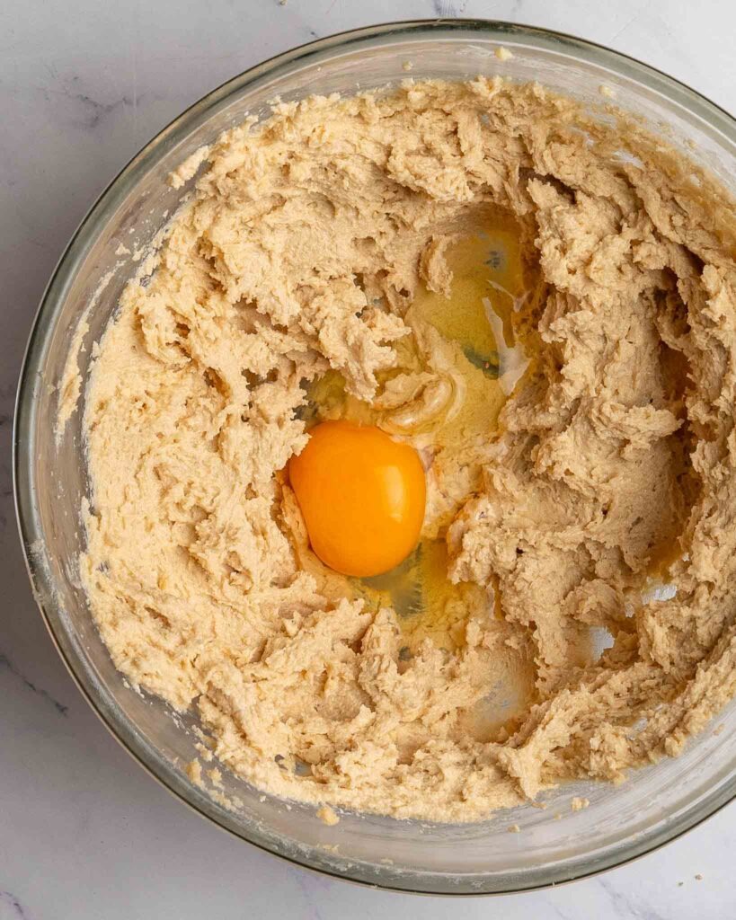 Egg in a mixing bowl with cookie dough batter.