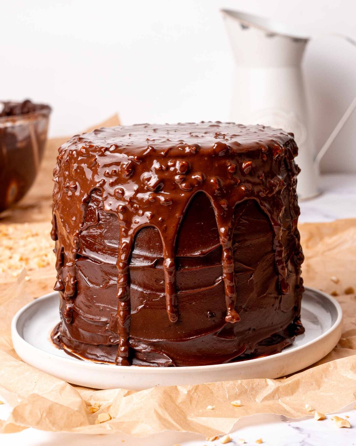 Ferrero Rocher chocolate fudge cake on a plate, with a nutty chocolate ganache dripping down.
