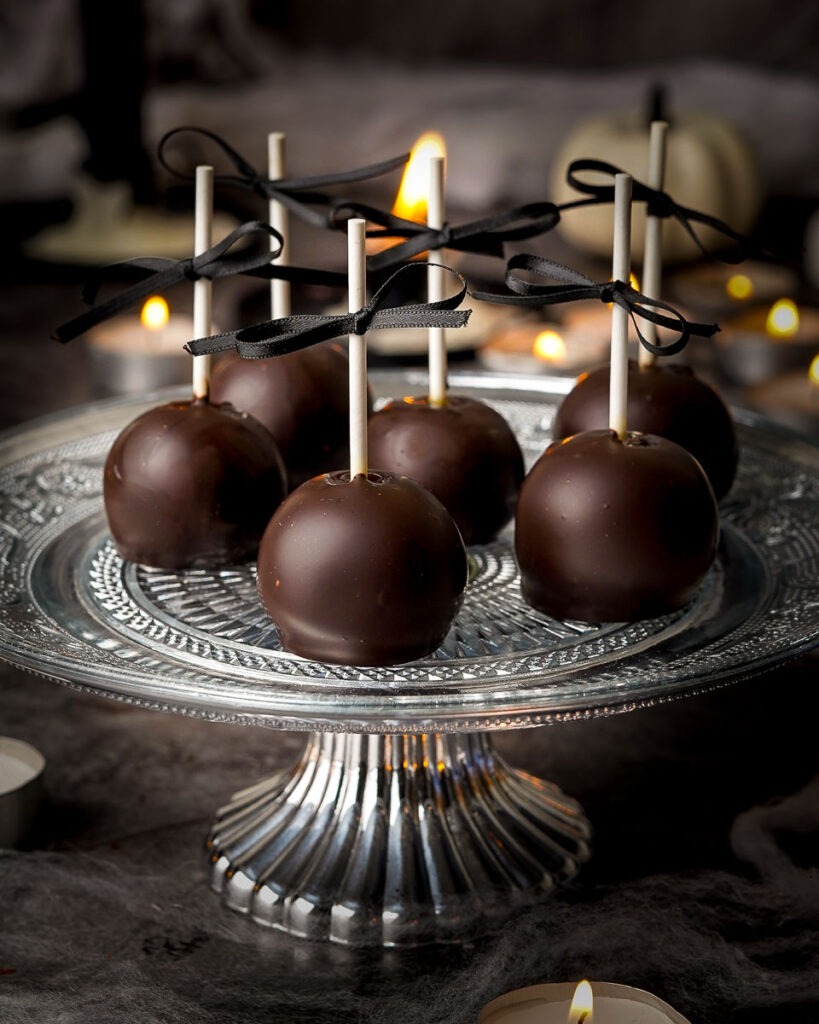 Brownie-Candy-Apple-Pops (Halloween-Cake-Pops-Idea.jpg - Ems Foodie Fix Brownie candy apple pops on a cake stand.