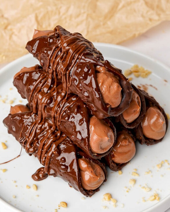Stack of Ferrero Rocher-inspired cannoli made with tortillas, drizzled with melted chocolate – air fryer dessert hack