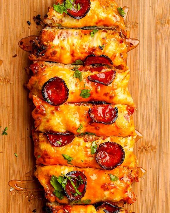 Garlic Bread Pizza With a Hot Honey Drizzle on a board already sliced.