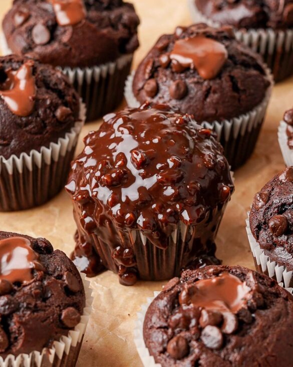 Ferrero Rocher Muffins filled with Nutella with one muffin in the middle drizzled in a nutty chocolate ganache.