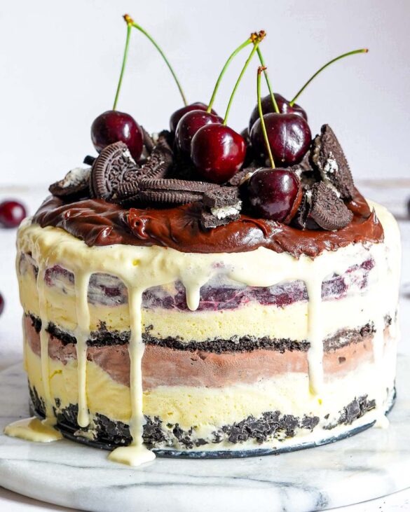 Black Forest Ice Cream Cake with oreo cookies and cherries on top.