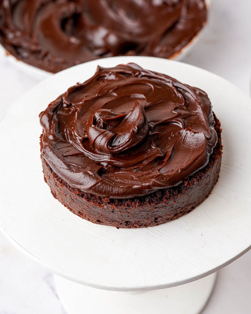 Mini matilda cake being decorated wth chocolate ganache.