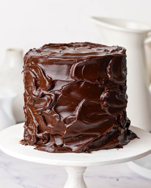 Mini Matilda Chocolate Cake on a cake stand covered in a messy chocolate ganache.