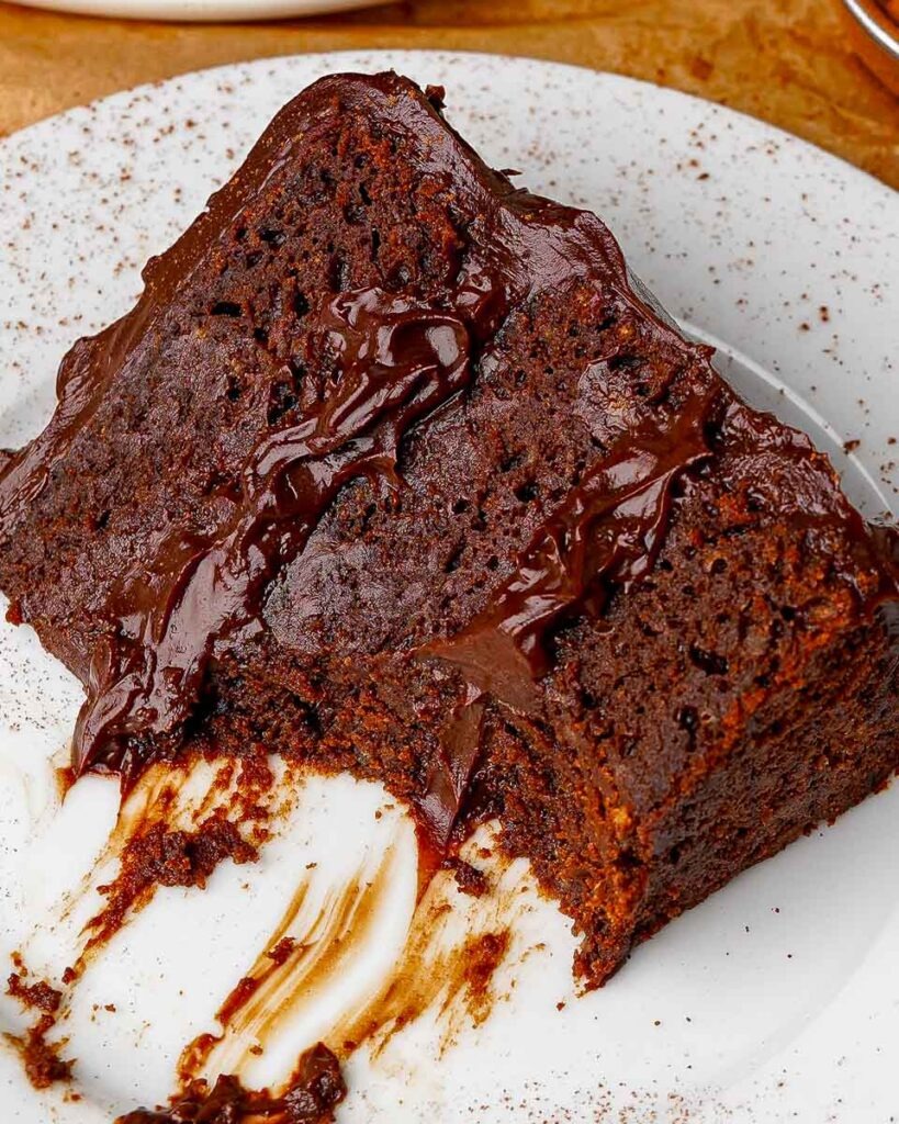 A slice of six ingredient death by chocolate cake with a piece missing. 