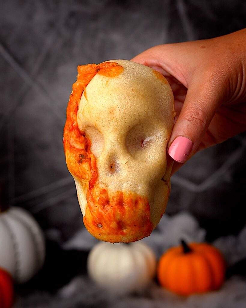 Pizza Skulls for Halloween with red sauce and cheese oozing out.