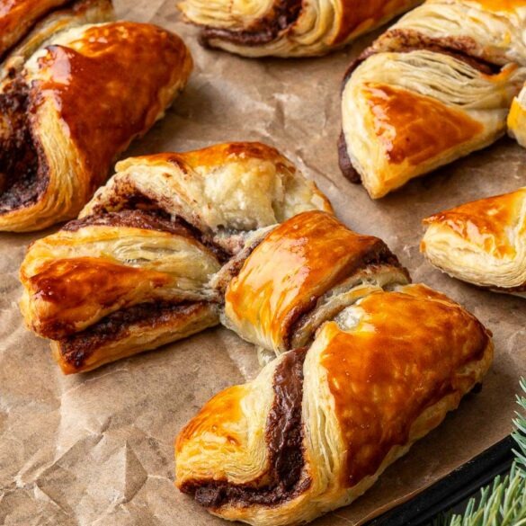 Puff pastry bows on a baking tray.