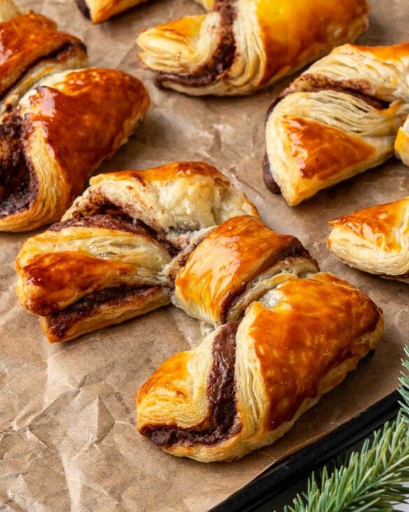 Puff pastry bows on a baking tray.