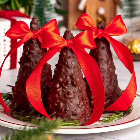 Ferrero Rocher Chrsitmas cones made with ice cream cones, dipped in nutty melted chocolate with a red bow on top.
