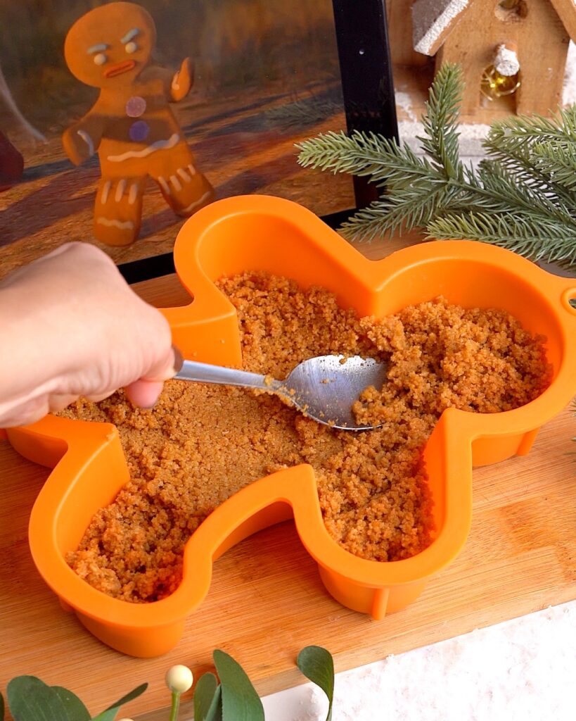 Gingerbread man shaped biscoff cheesecake served upside down.