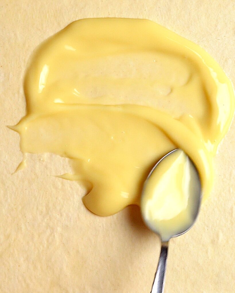 Spreading custard evenly over puff pastry sheet for homemade chocolate custard twists
