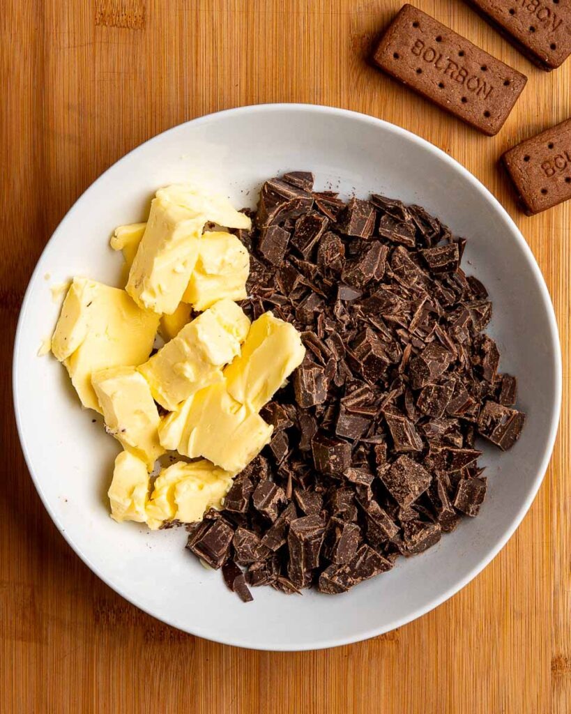 Chocolate and butter for fudgy bourbon biscuit brownies in a bowl.