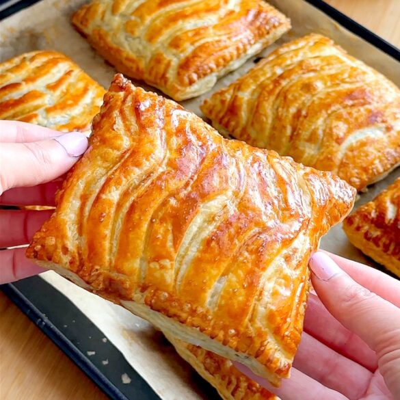 Greggs style steak bake with golden flaky puff pastry and wavy line pattern on top.