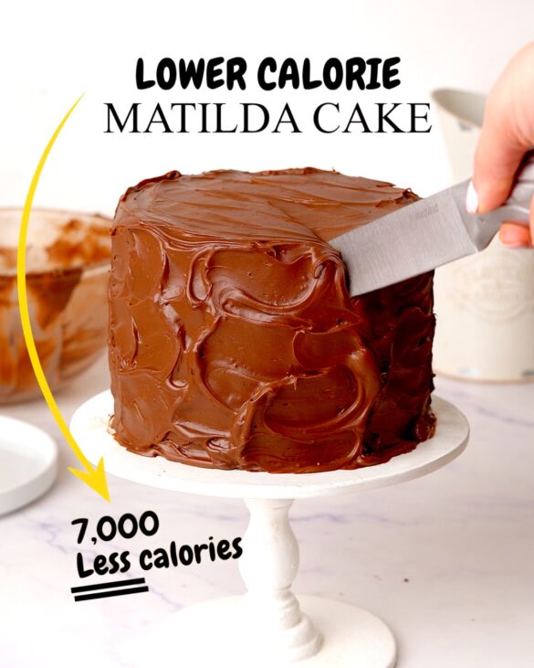 Fudgy Matilda cake covered in messy chocolate ganache being cut with a knife.