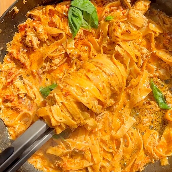 Marry me chicken pasta being swirled in a skillet.