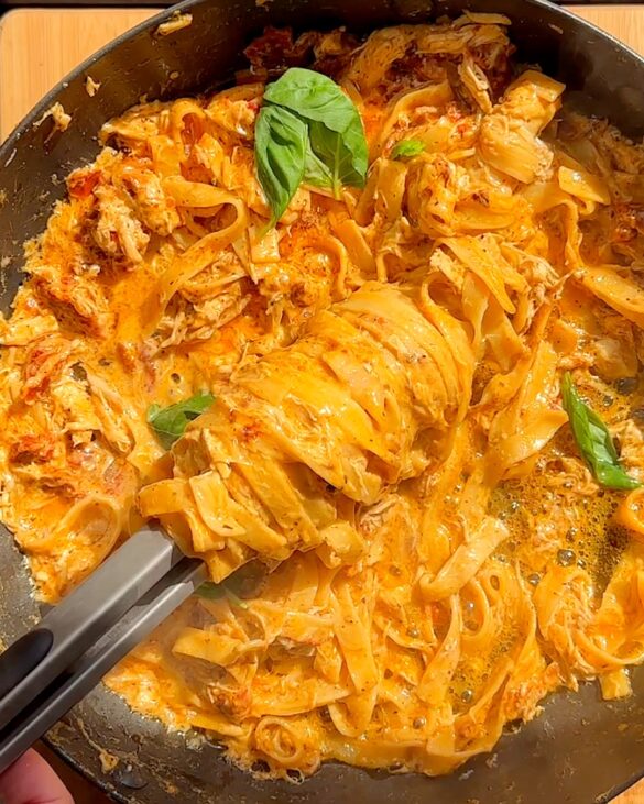 Marry me chicken pasta being swirled in a skillet.
