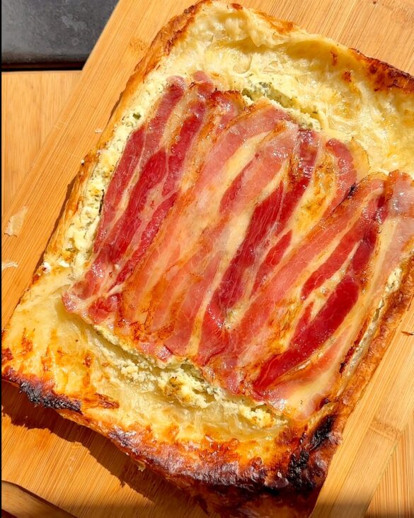 Boursin bacon tart that was baked upside down after its been flipped on a wooden board.
