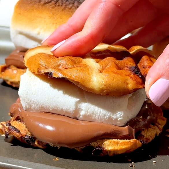 Hot cross bun s'mores with melted chocolate and marshmallow in the middle.