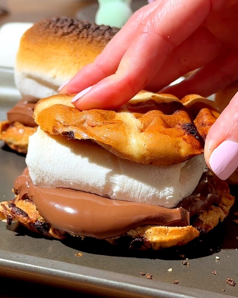 Hot cross bun  s'mores with melted chocolate and marshmallow in the middle.
