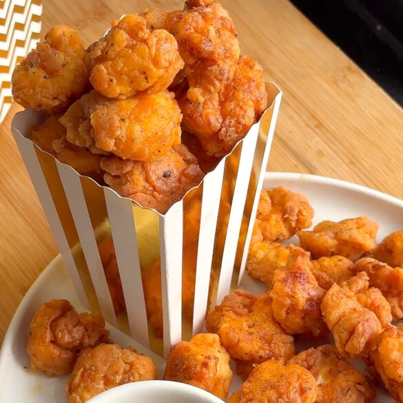 KFC style Popcorn Chicken in a white and gold stripy popcorn box.